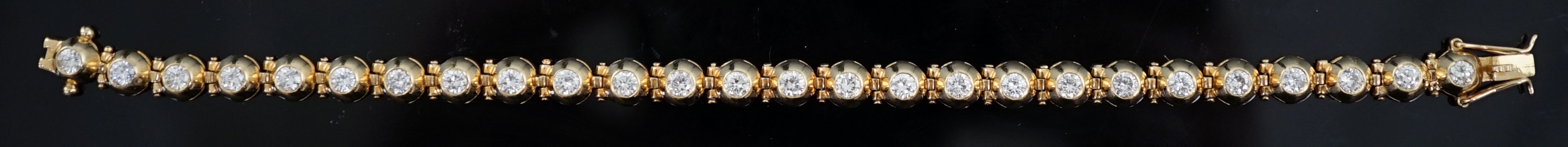 A modern 18ct gold and twenty six round brilliant cut diamond set line bracelet